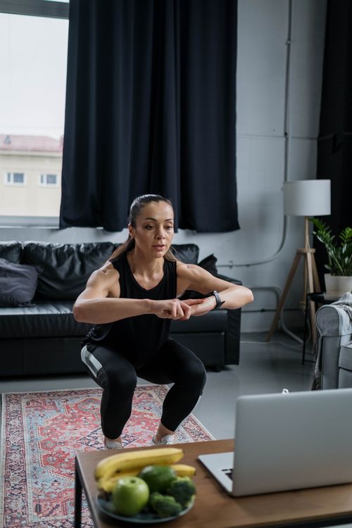 Person performing a squat exercise in a living room